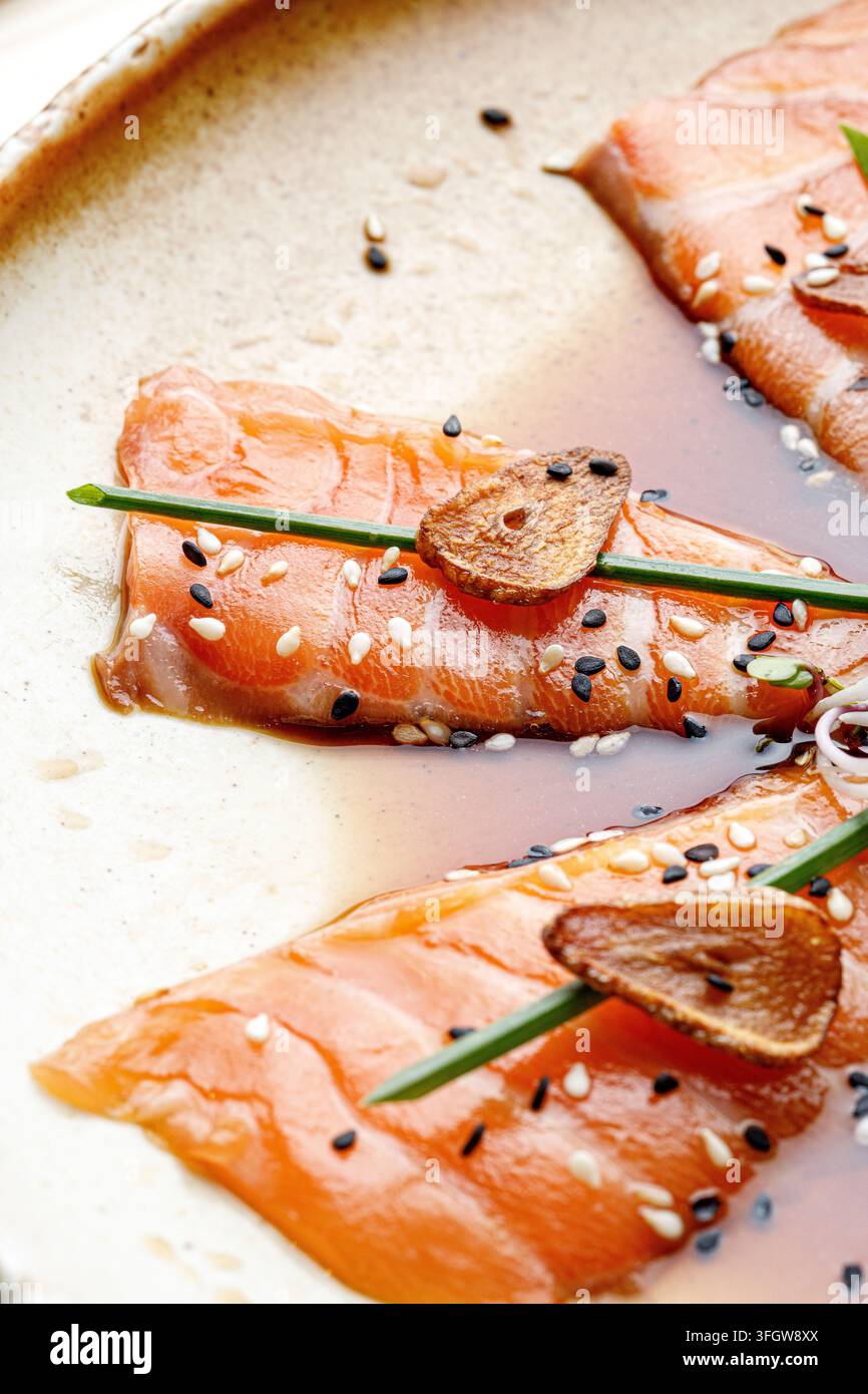 Gourmet-Lachs-Sashimi mit gebratenem Knoblauch und Schnittlauch Stockfoto