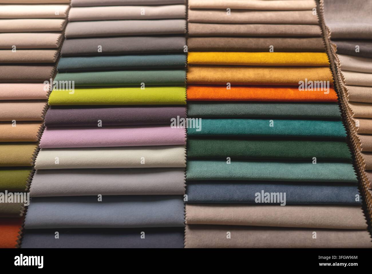 Stoffmuster ordnen sich in einem Raster aus verschiedenen Farben an. Textilproben zeigen unterschiedliche Schattierungen zusammen. Stockfoto
