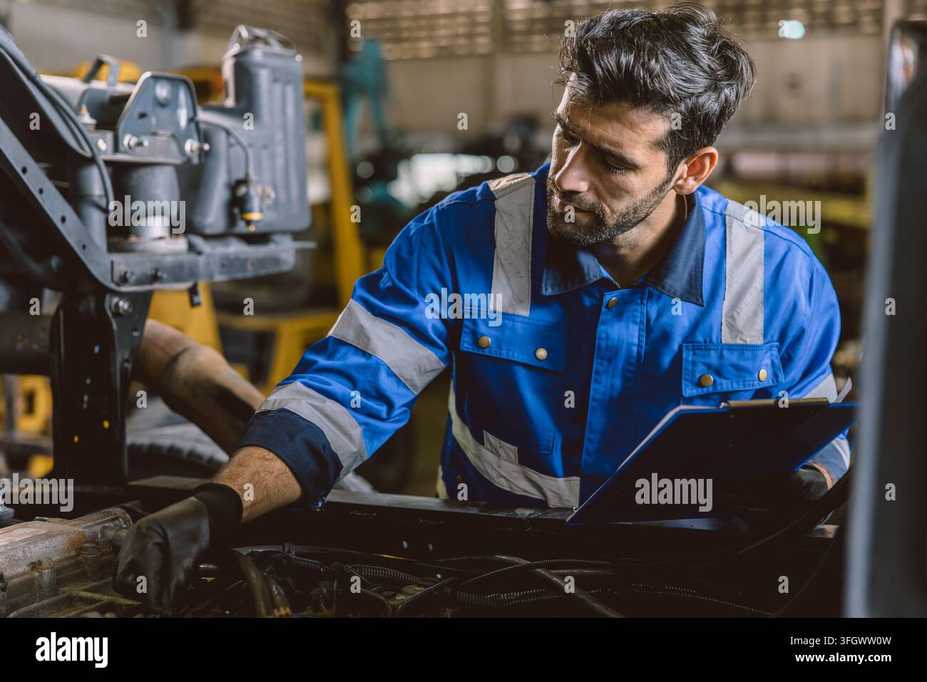 Hispanic Lateinindischer männlicher Mechaniker repariert LKW-Motor in der Autowerkstatt, LKW-Autotechniker arbeitet an der Wartung des Fahrzeugmotors Stockfoto