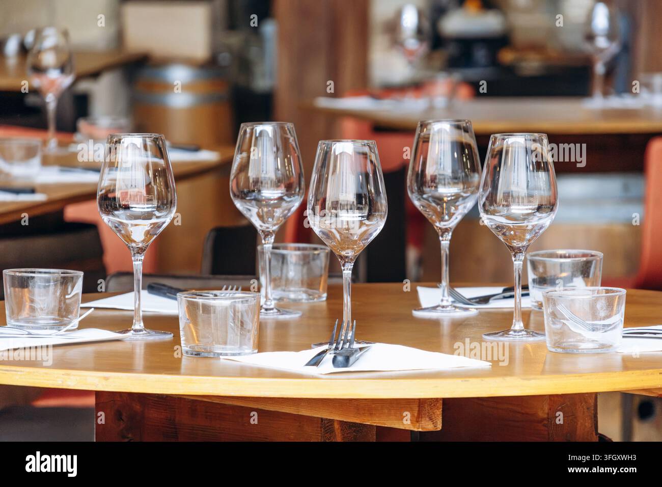 Restauranttisch mit leeren Weingläsern, Wassergläsern, Besteck und Servietten gedeckt Stockfoto