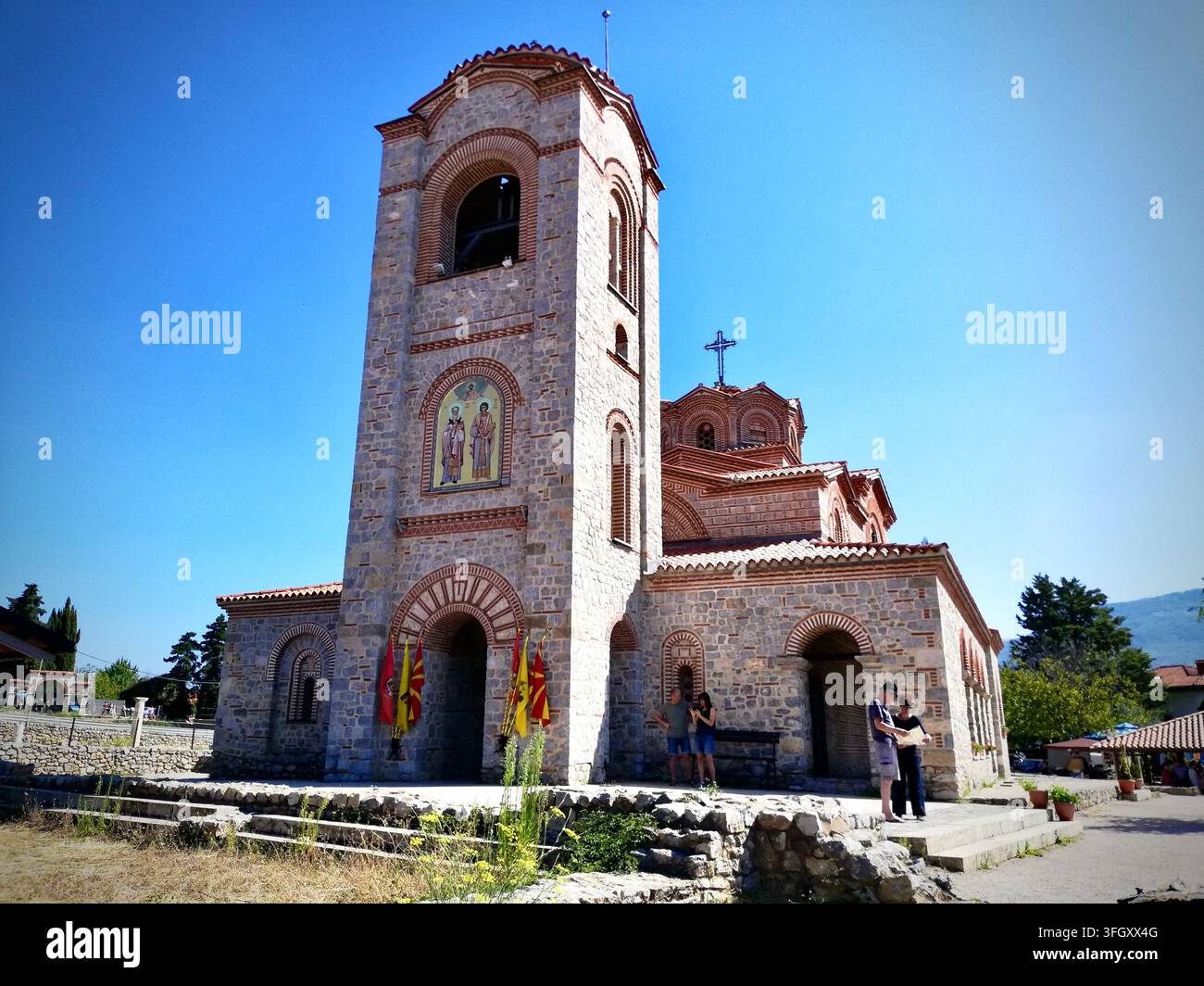 Byzantinische Kirche der Heiligen Clemens und Panteleimon in Ohrid, Nordmazedonien, mit aufwendiger Stein- und Ziegelmauer unter einem klaren blauen Himmel - Smartphone-aufgenommenes Stockfoto