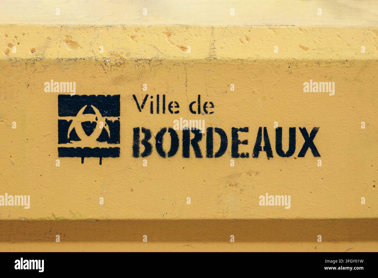 Bordeaux, Frankreich - 14. Juli 2026: Das municipale Logo der Ville de Bordeaux (Stadt Bordeaux) auf einer gelben Betonbarriere entlang der Uferpromenade gestencelt Stockfoto