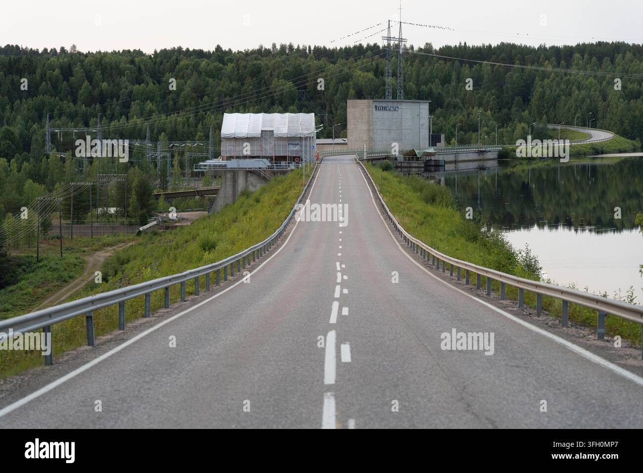 Eine Straße kreuzt das Vanttauskoski-Wasserkraftwerk am Kemijoki-Fluss in Finnland, das Wasser zur Stromerzeugung nutzt. Stockfoto