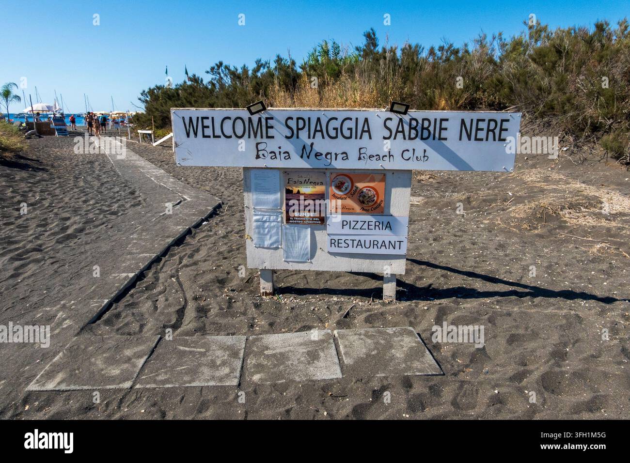 Vulcano, ME - IT - 5. Sep 2026: Schild am Spiaggia Sabbie Black auf der Insel Vulcano begrüßt Besucher im Baia Black Beach Club und kennzeichnet die Pizzeria an Stockfoto