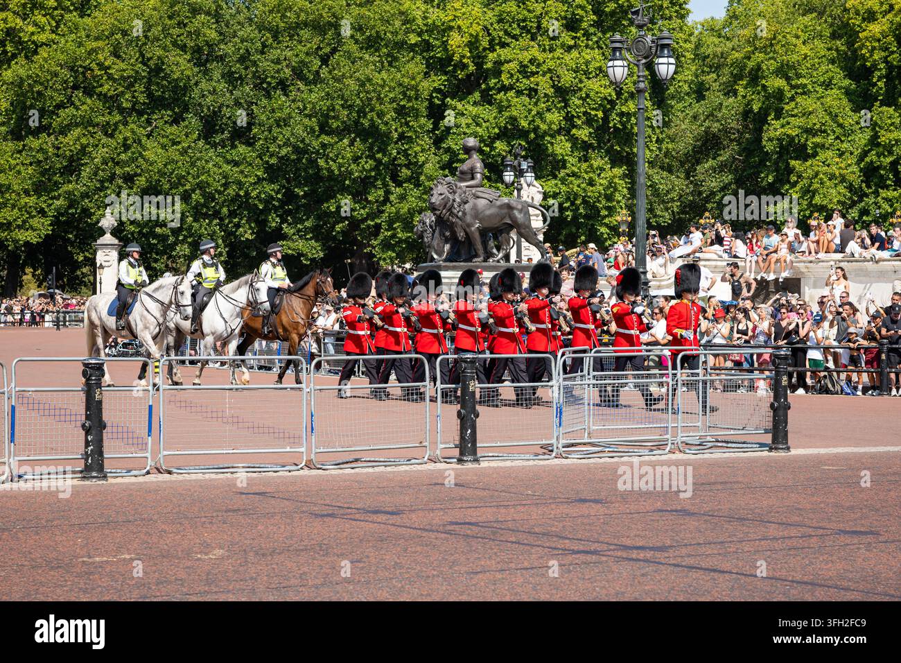 London, Greater London, Vereinigtes Königreich, 14. August 2026. Königliche Wachen in scharlachroten Tuniken und Bärenfellmützen marschieren die Straße entlang, begleitet von m Stockfoto