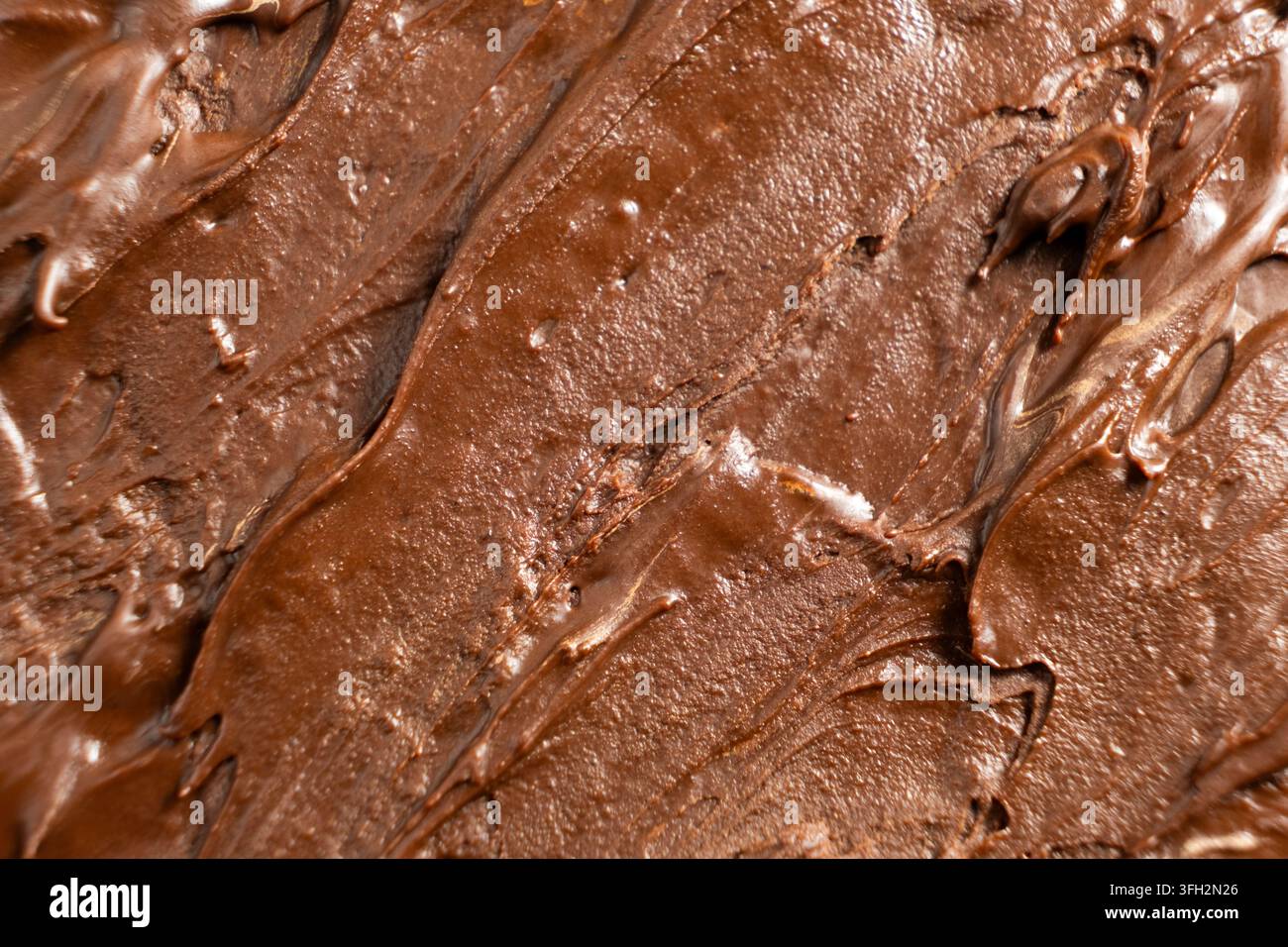 Cremige Milchschokoladenpaste mit strukturierten Spachtelstrichspuren. Stockfoto