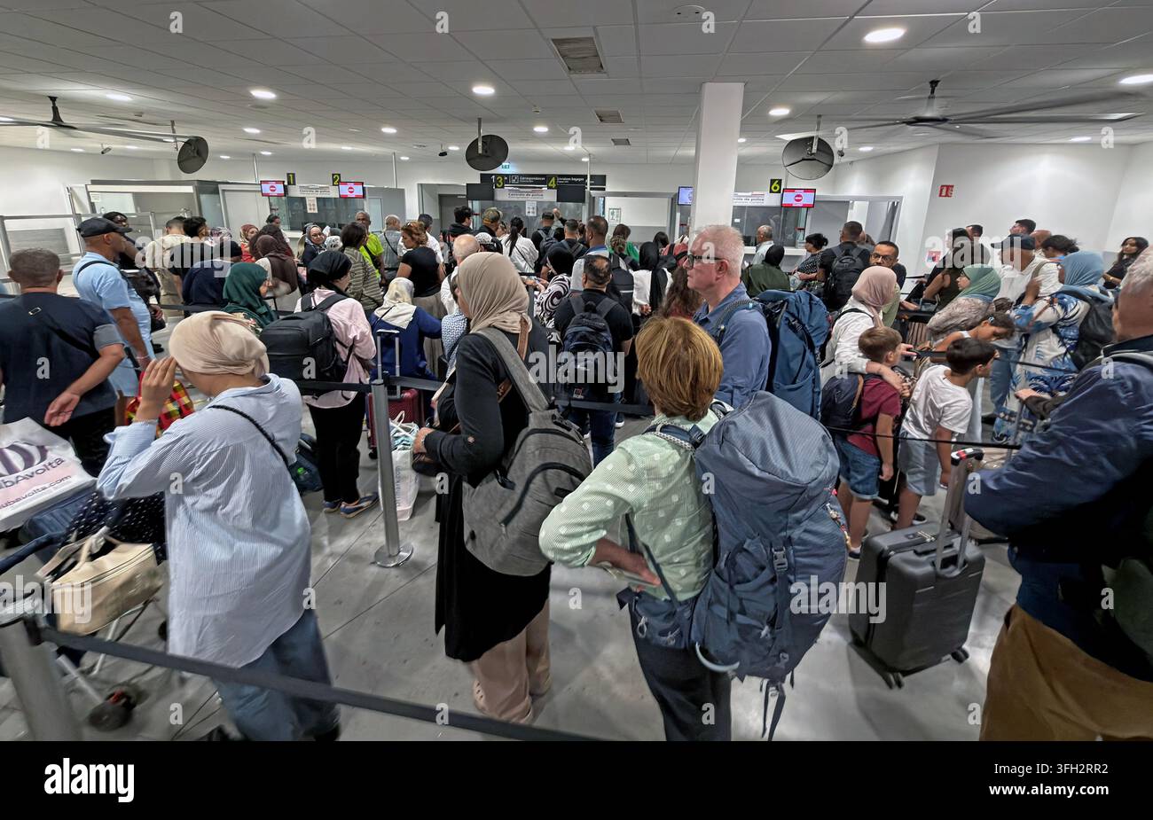 Lange Schlangen am Passkontrollpunkt des Flughafens Lyon-Saint Exupéry, während Reisende während der Implementierung des EU-Ein-/Ausreisensystems warten. Stockfoto