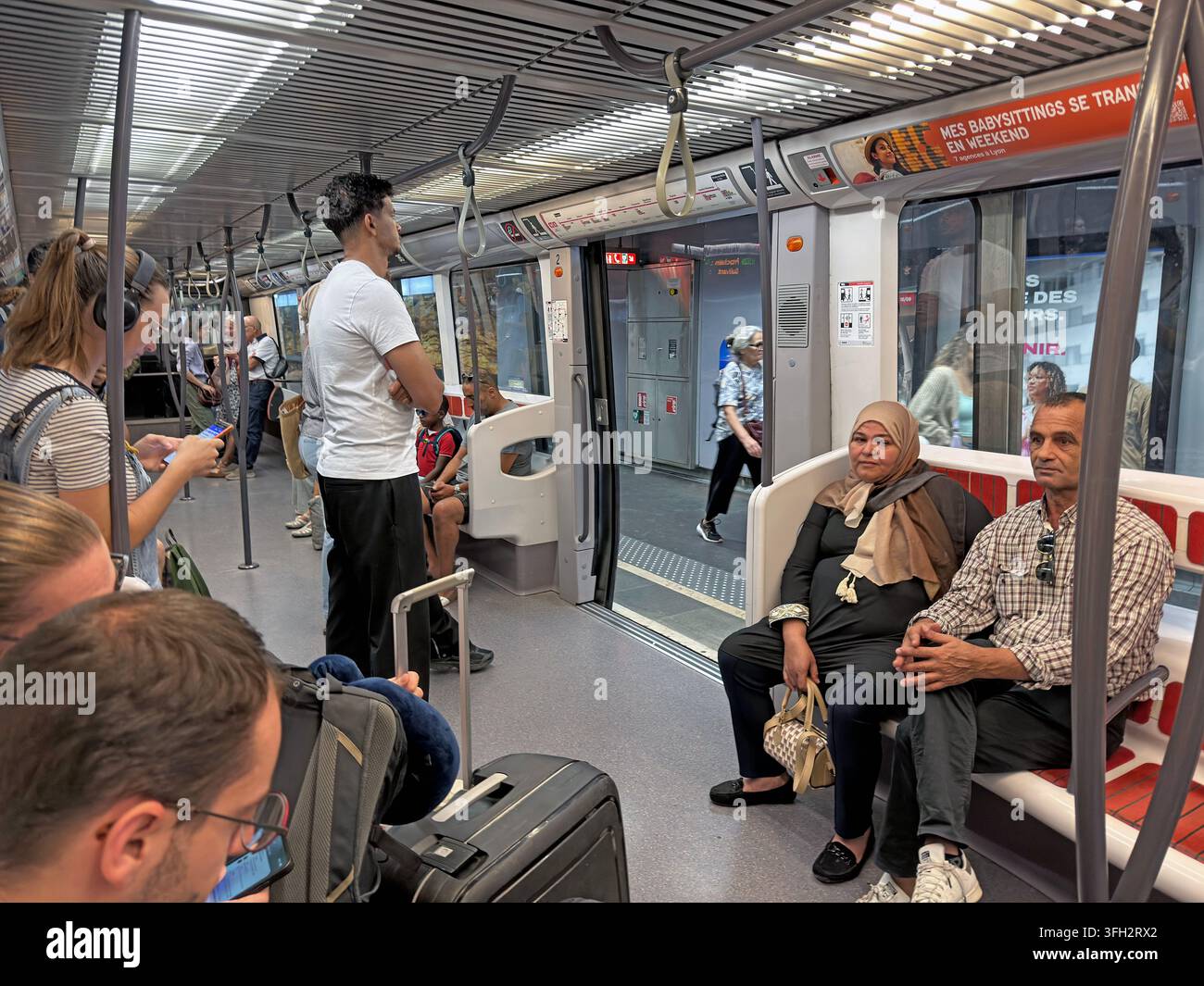 Pendler und Besucher reisen in einem Zug der TCL Metro Linie A in Lyon, Frankreich, während einer alltäglichen Stadtfahrt. Stockfoto