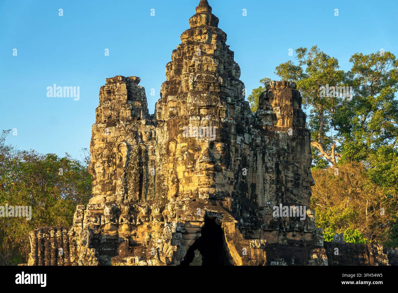 Gigantisches Stein-Buddha-Gesicht am Südtor der antiken Stadt Angkor Thom, Angkor bei Sonnenuntergang, Siem Reap, Kambodscha Stockfoto