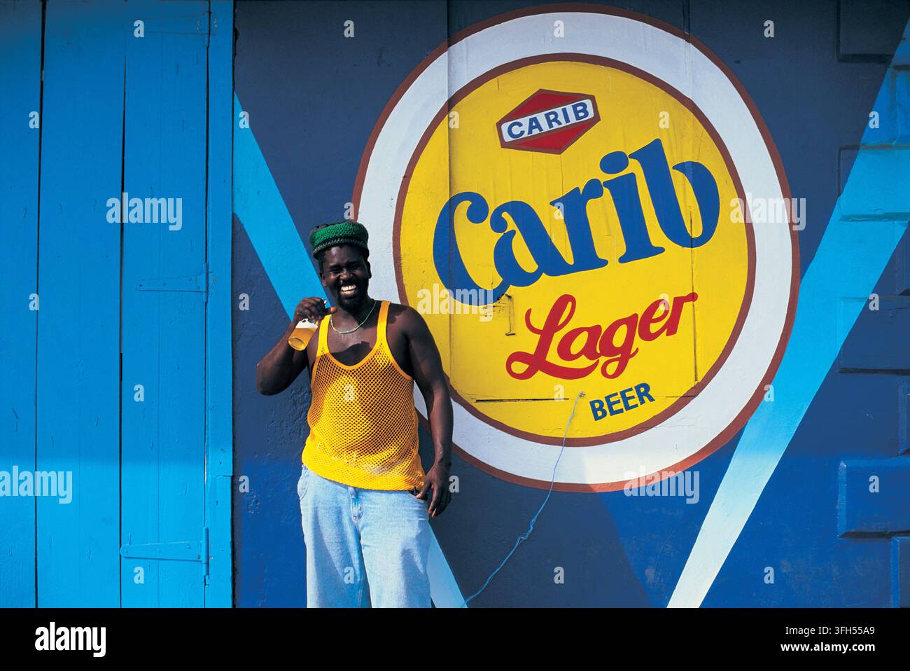 Mann trinkt laut Werbung für Carib Lager, Karibik Stockfoto