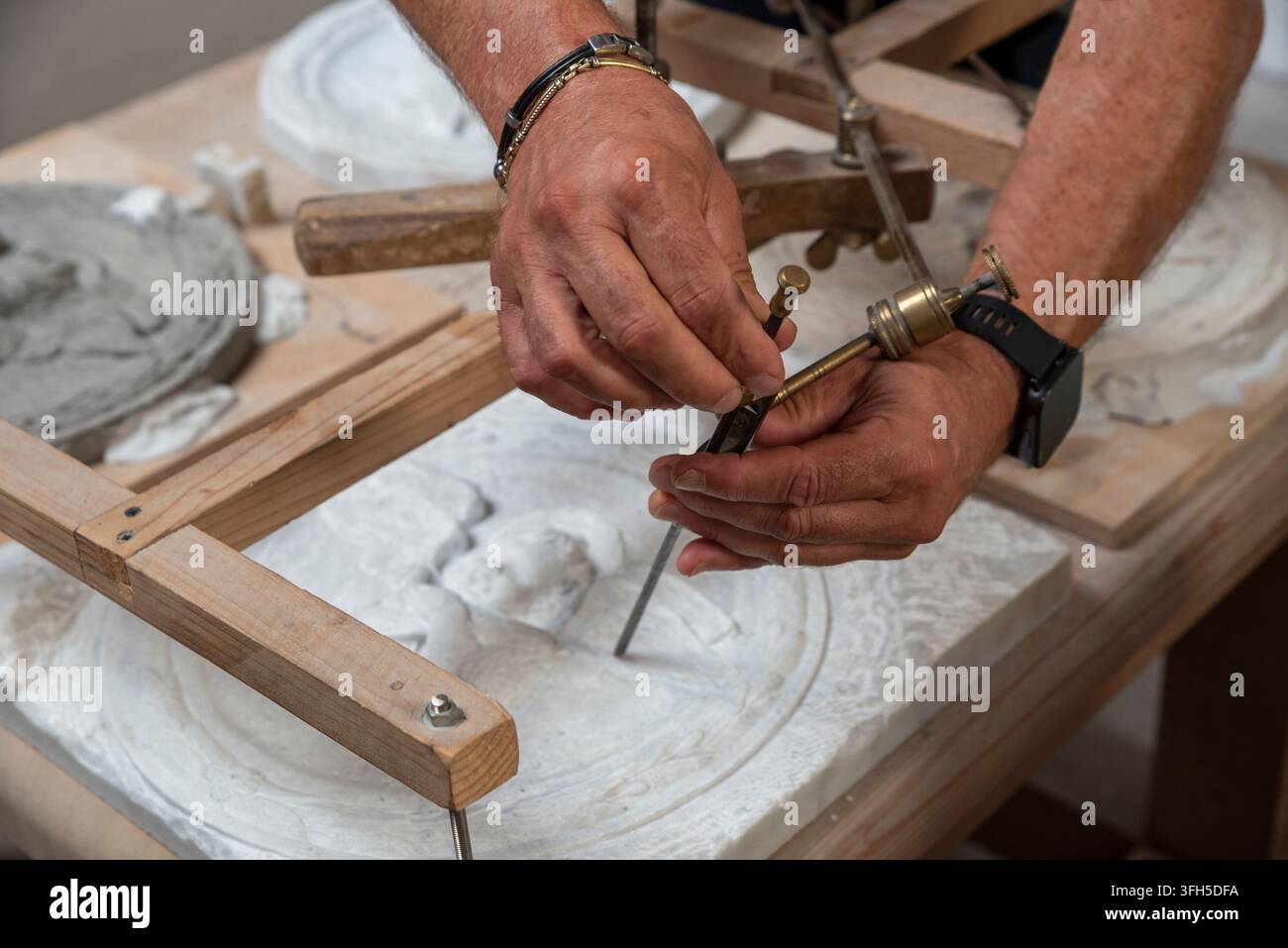 Verwenden des Pantografen, um eine Kopie eines Marmor-Basenreliefs herzustellen. Meisterhandwerker bei der Arbeit. Stockfoto