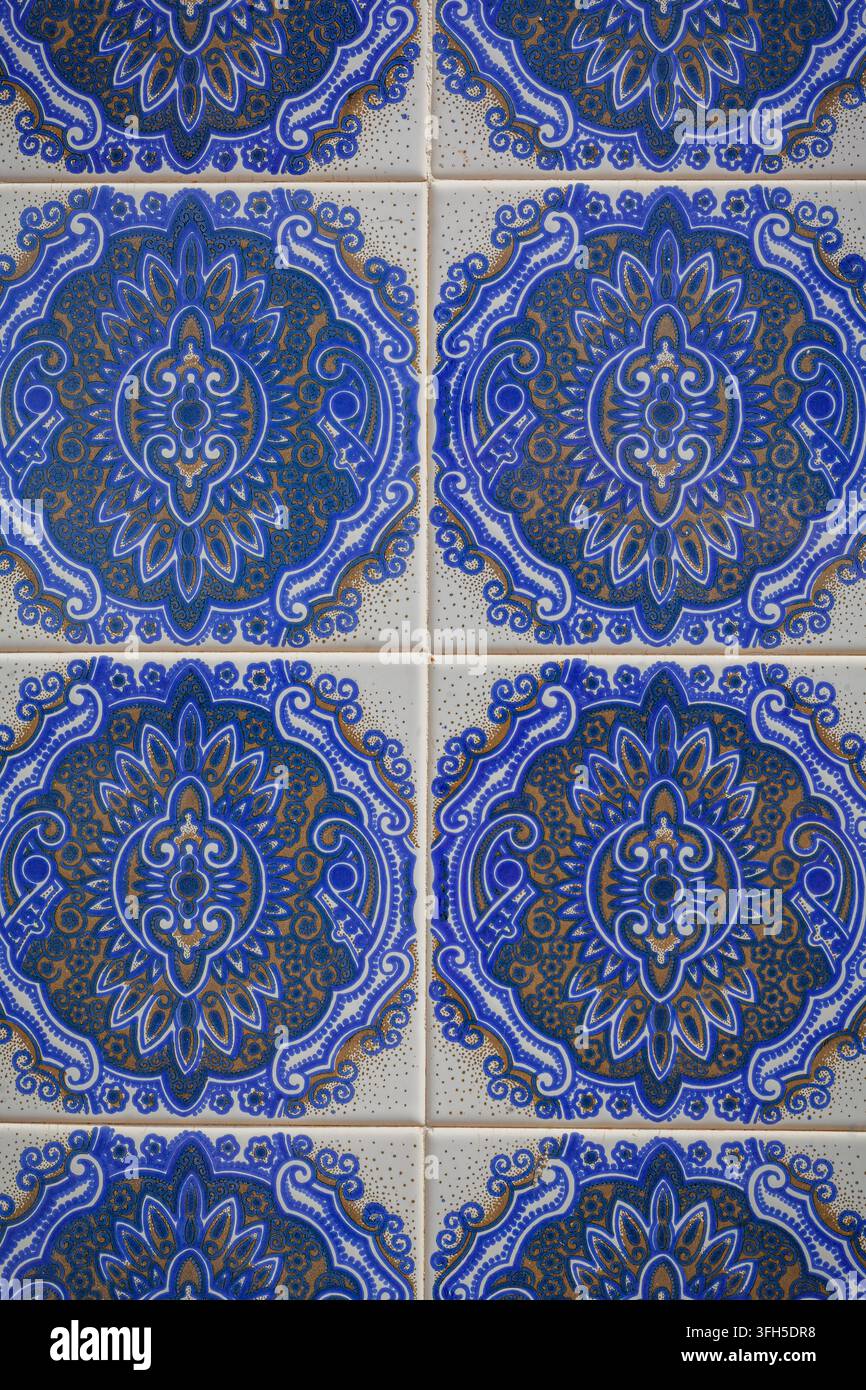 Nahaufnahme von traditionellen blauen und weißen Keramikfliesen mit einem aufwendigen ornamentalen geometrischen und floralen Muster an einer Wand. Stockfoto