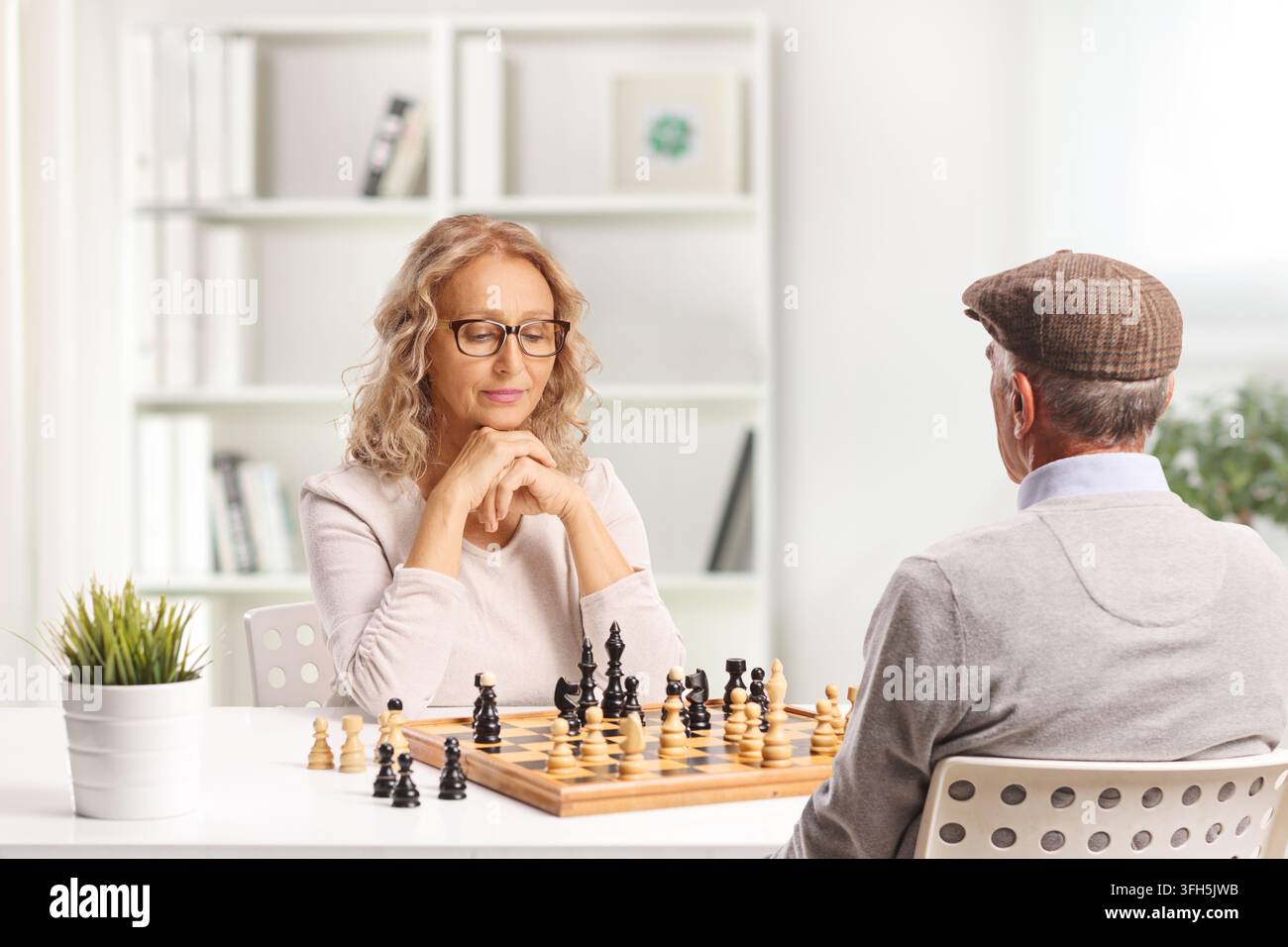 Älteres Paar beim Schachspiel zu Hause Stockfoto