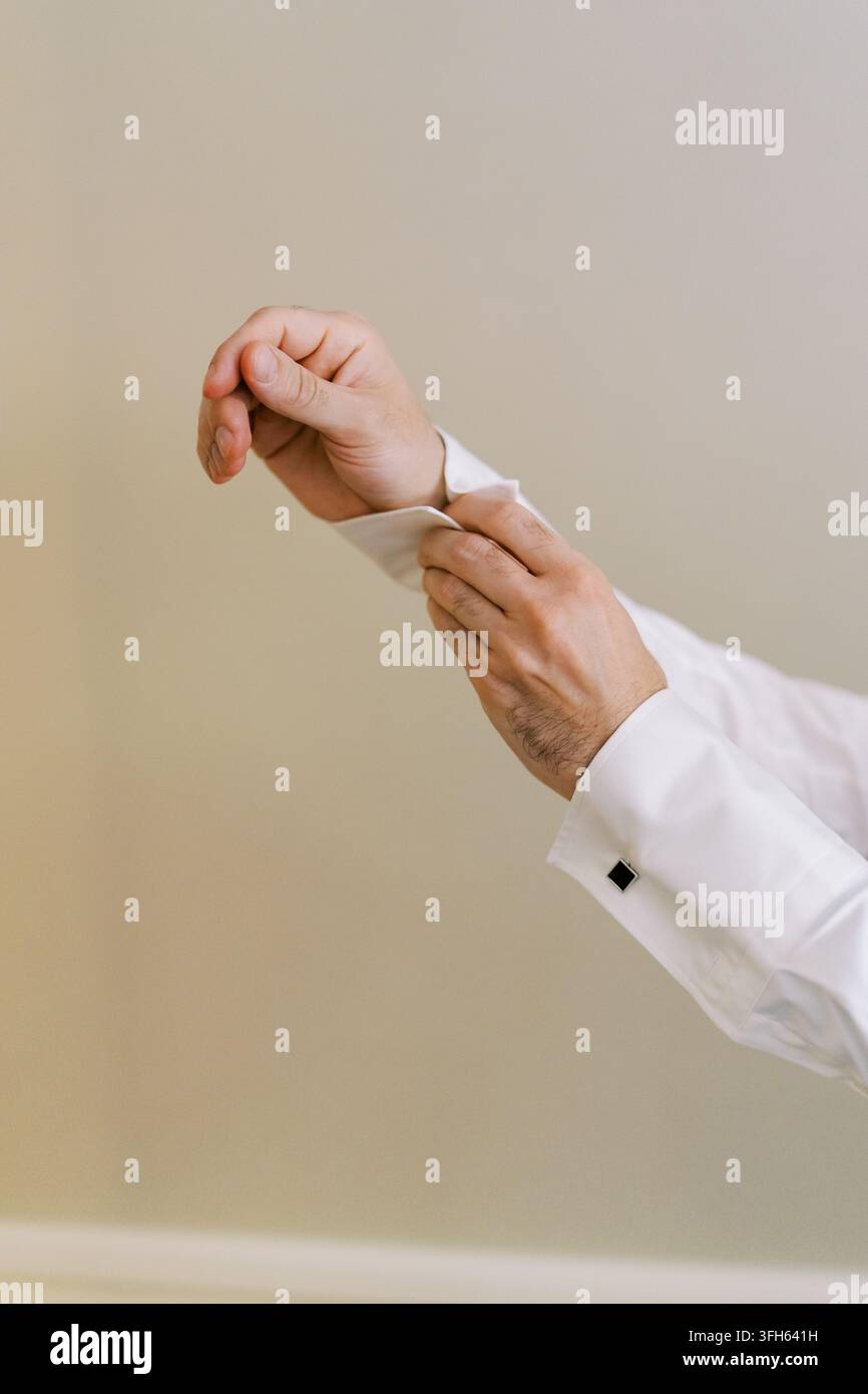 Mann, der einen weißen Hemdärmel verstellt Stockfoto