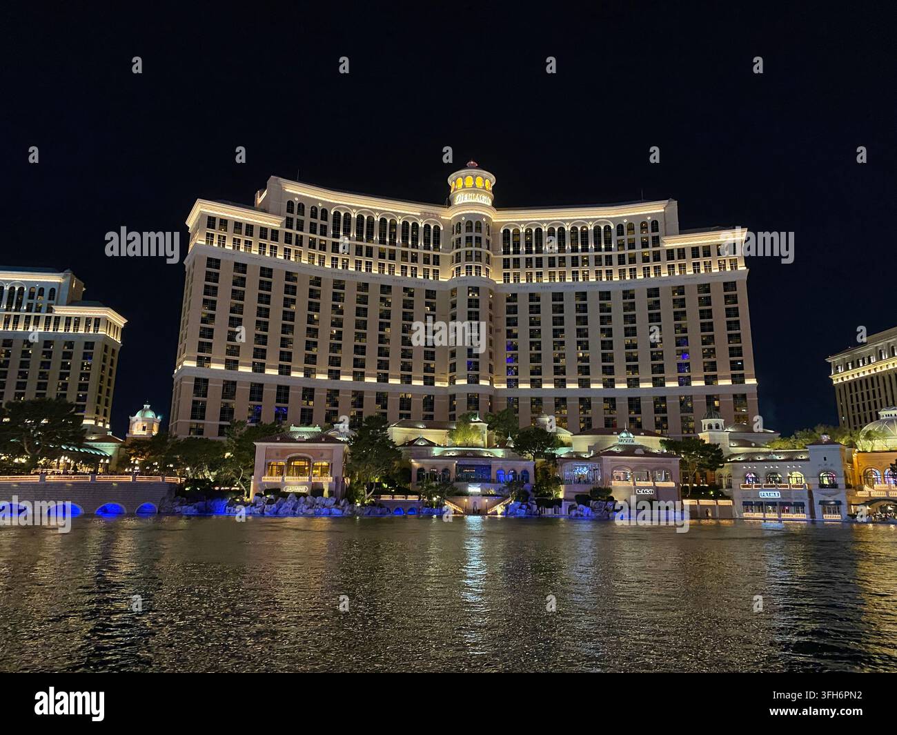 Blick über den großen Teich zur Vorderfassade des Bellagio-Hotels und der Restaurants, bei Nacht, im Sommer, in Las Vegas, Nevada, USA - Smartphone-aufgenommenes Stockfoto