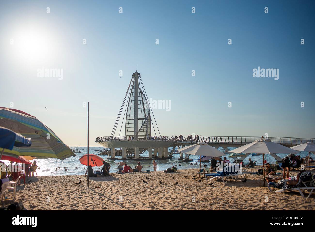 Puerto Vallarta, Jalisco, 09 09 2026. Der Los Muertos Beach Pier ist voller Touristen, die an einem sonnigen Tag entlang des Küstenlandes wandern. Zahlreiche Boote treiben Stockfoto