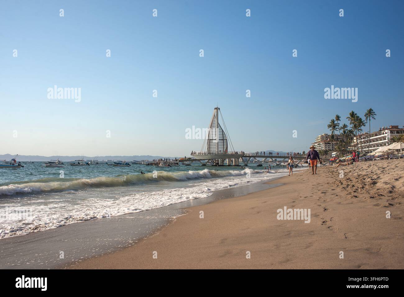 Puerto Vallarta, Jalisco, 09 09 2026. Der Los Muertos Beach Pier ist voller Touristen, die an einem sonnigen Tag entlang des Küstenlandes wandern. Zahlreiche Boote treiben Stockfoto