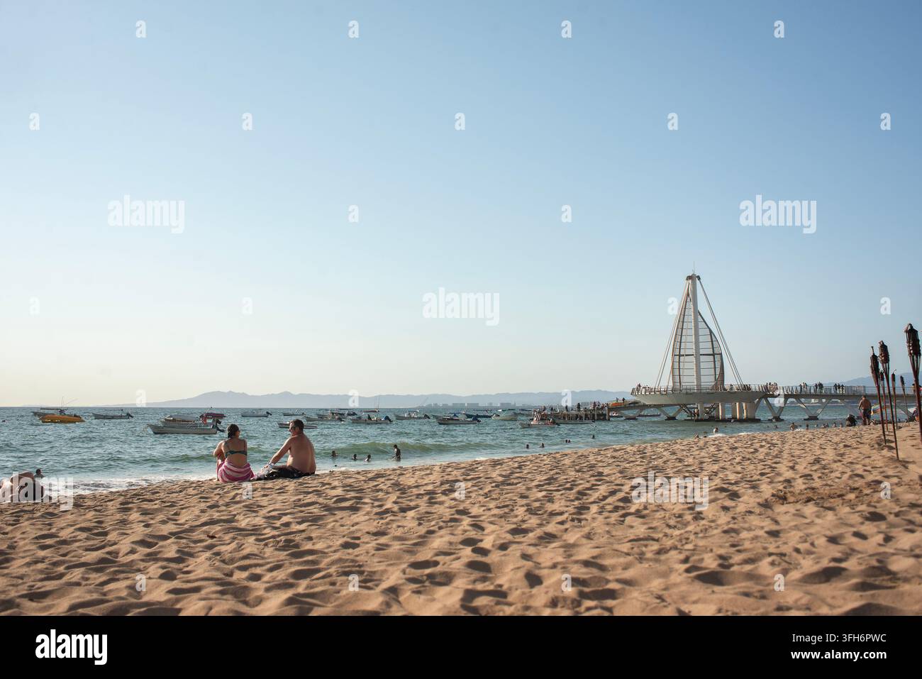 Puerto Vallarta, Jalisco, 09 09 2026. Der Los Muertos Beach Pier ist voller Touristen, die an einem sonnigen Tag entlang des Küstenlandes wandern. Zahlreiche Boote treiben Stockfoto