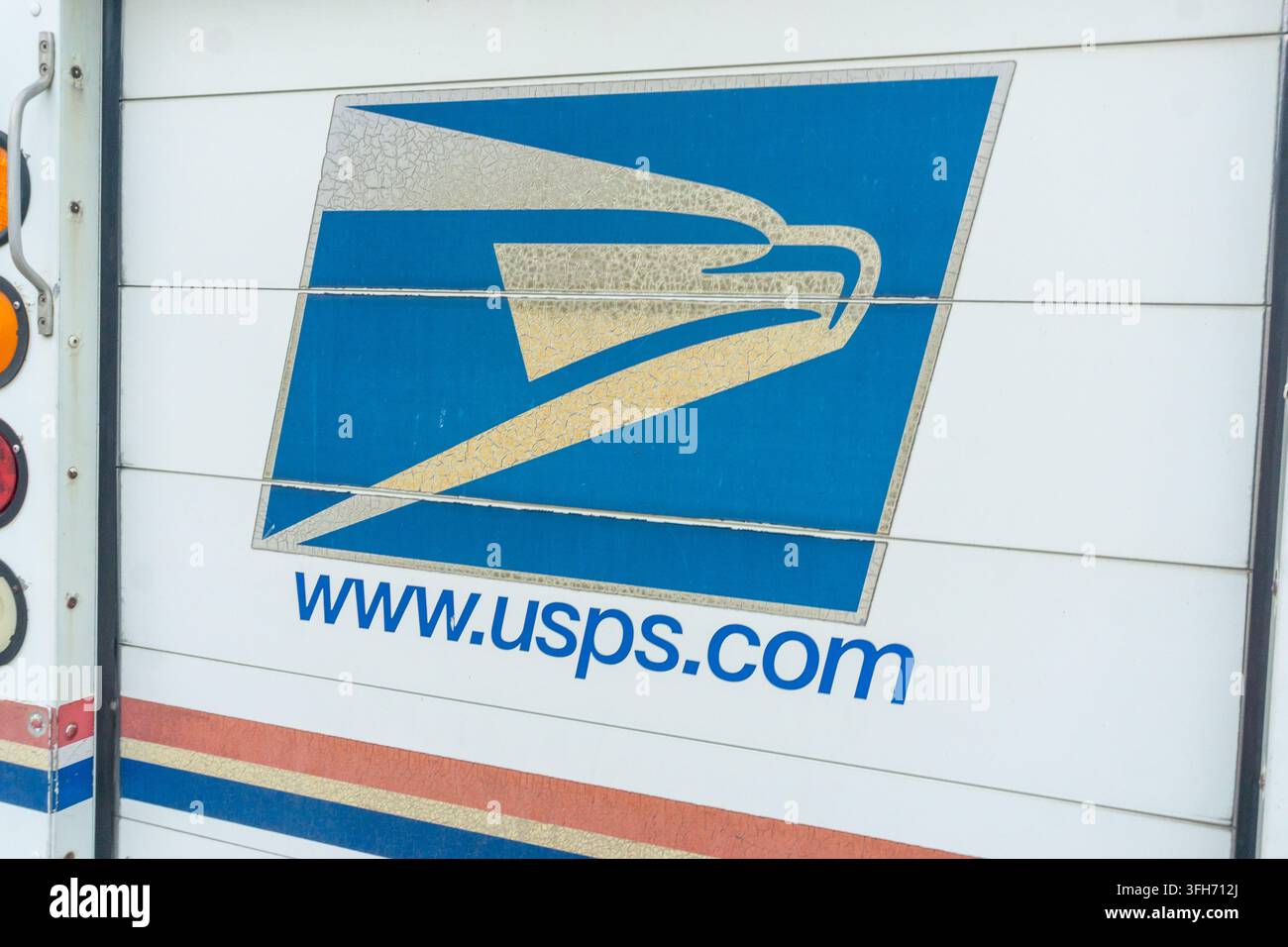 Nahaufnahme des Logos und der Webadresse des United States Postal Service an der Seite eines weißen Lieferwagens. Stockfoto