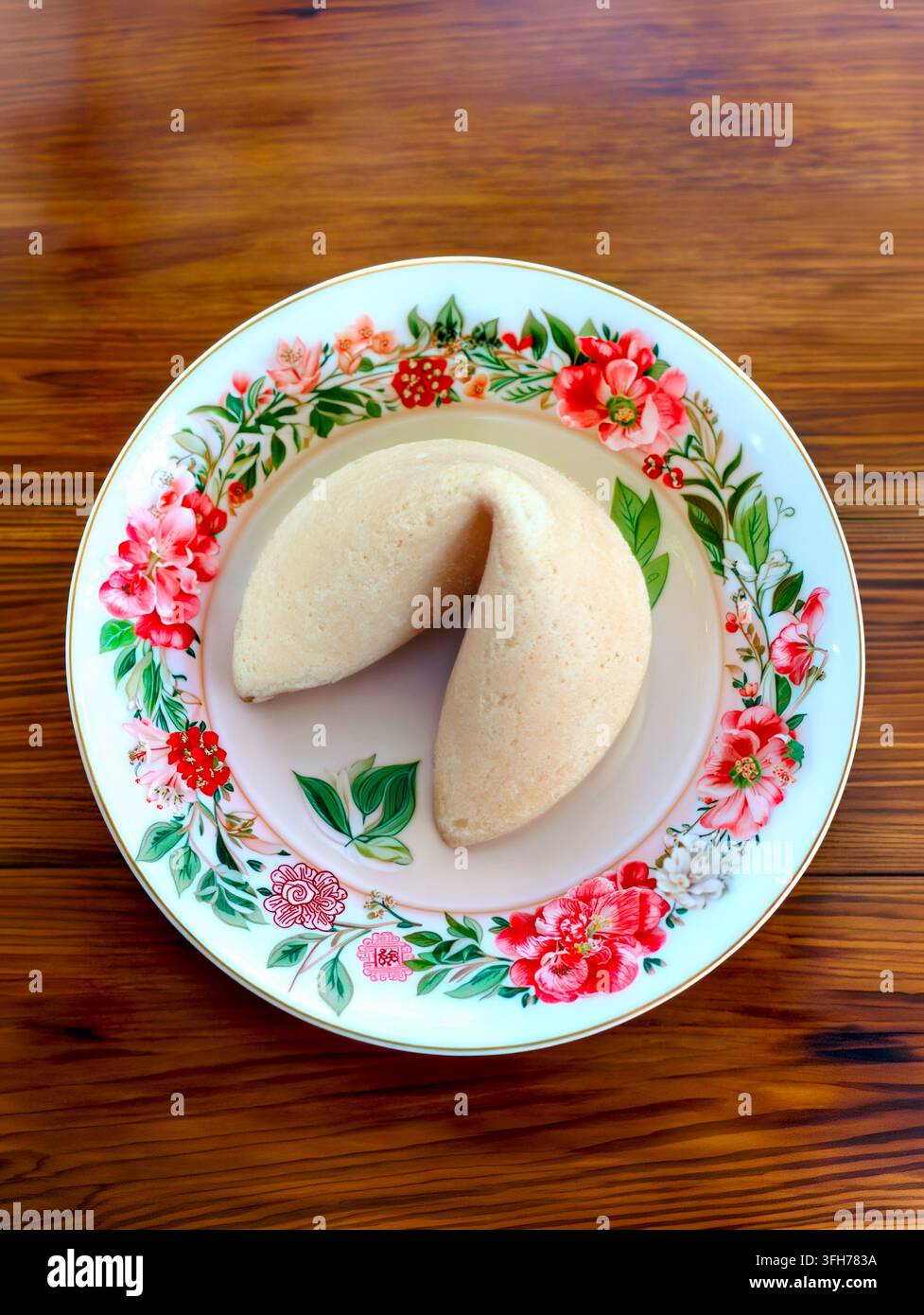 Fortune Cookie auf dekorativem Blumenmuster-Teller Stockfoto