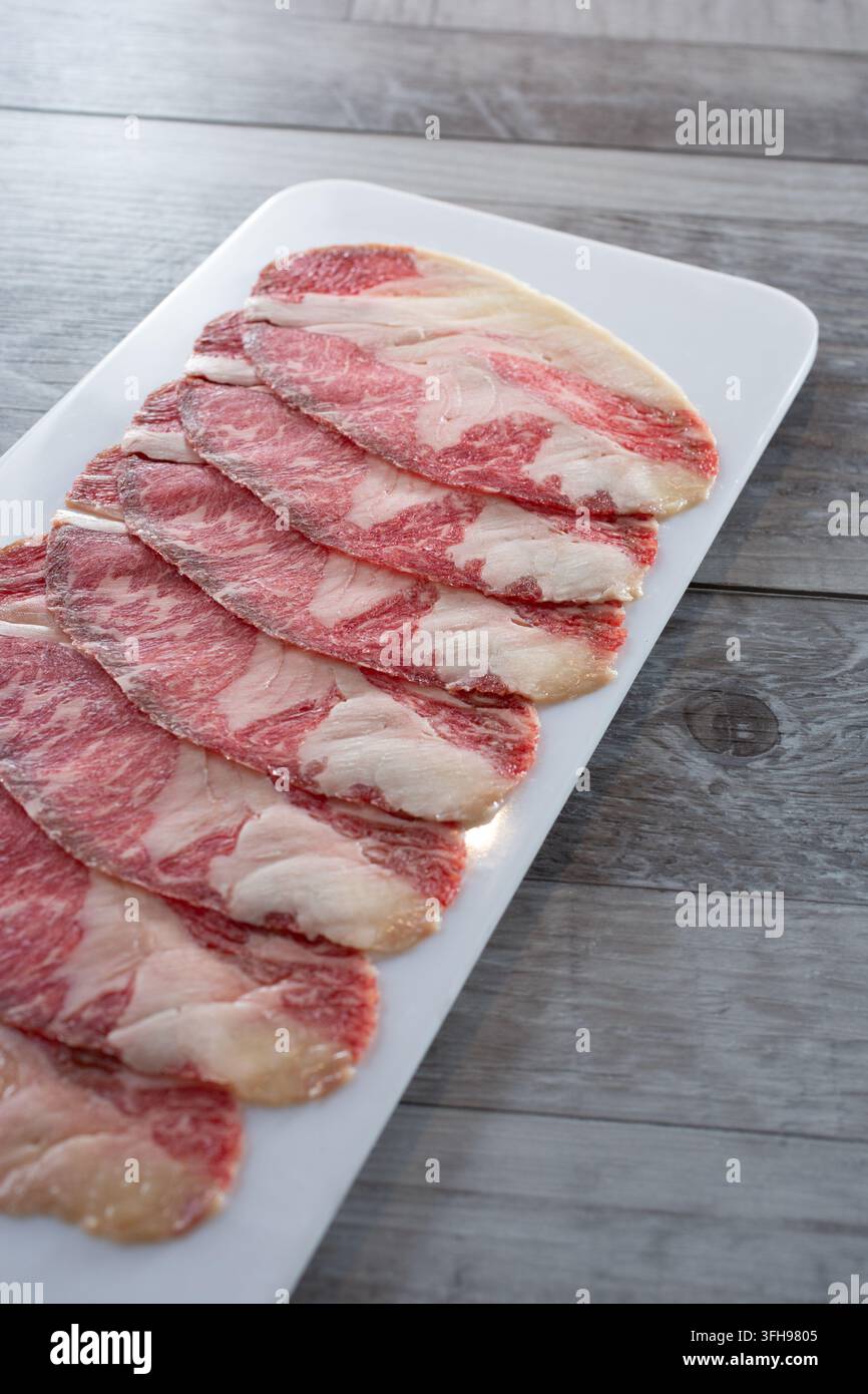 Eine Ansicht eines Tellers mit rohen Scheiben Wagyu-Rinderbrust. Stockfoto