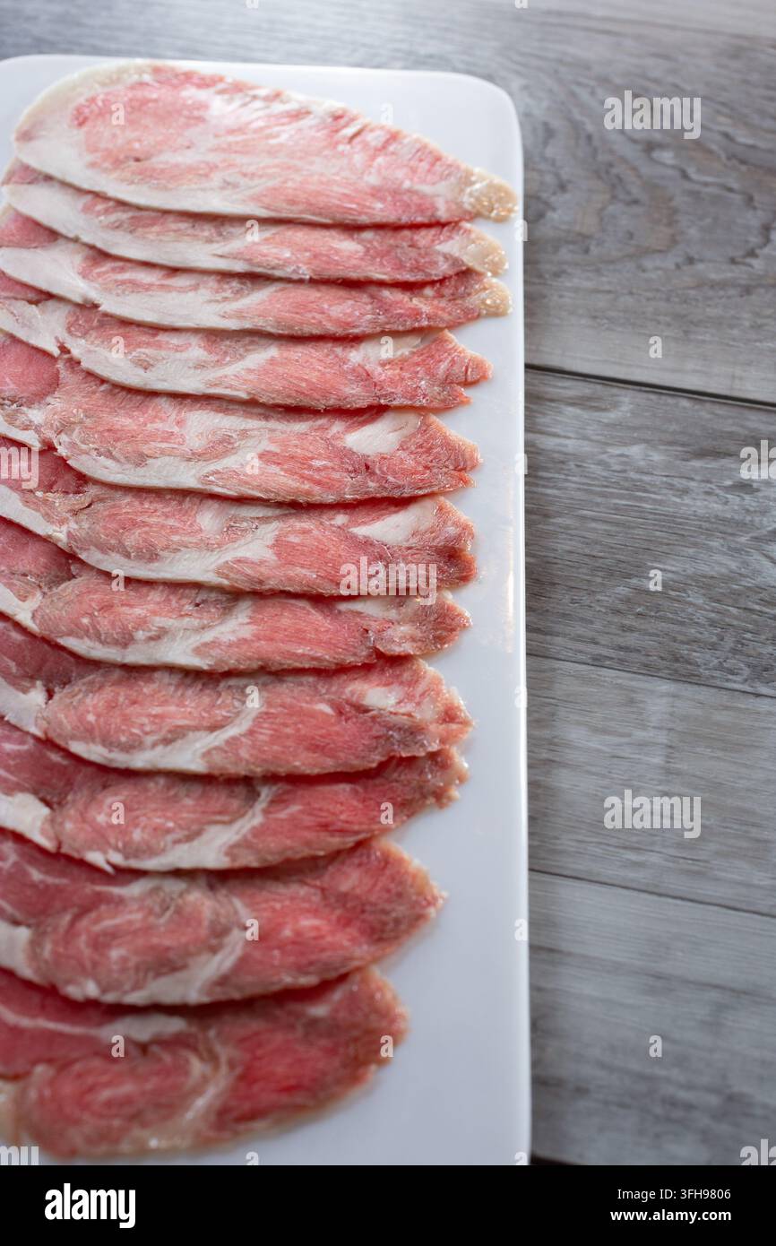 Eine Ansicht eines Tellers mit rohen Wagyu-Rindfleischscheiben. Stockfoto