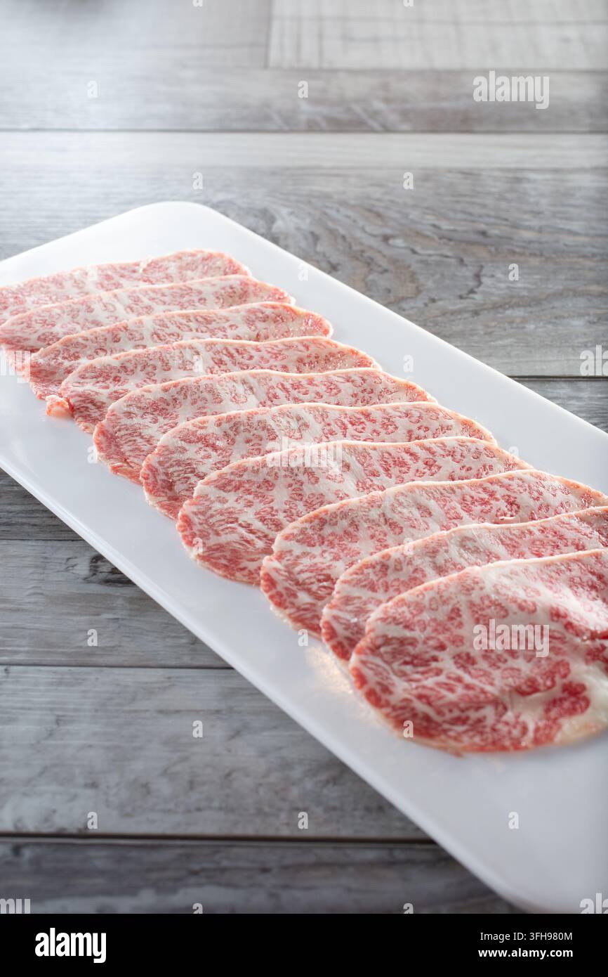 Eine Ansicht eines Tellers mit rohen Wagyu-Rindfleischscheiben. Stockfoto
