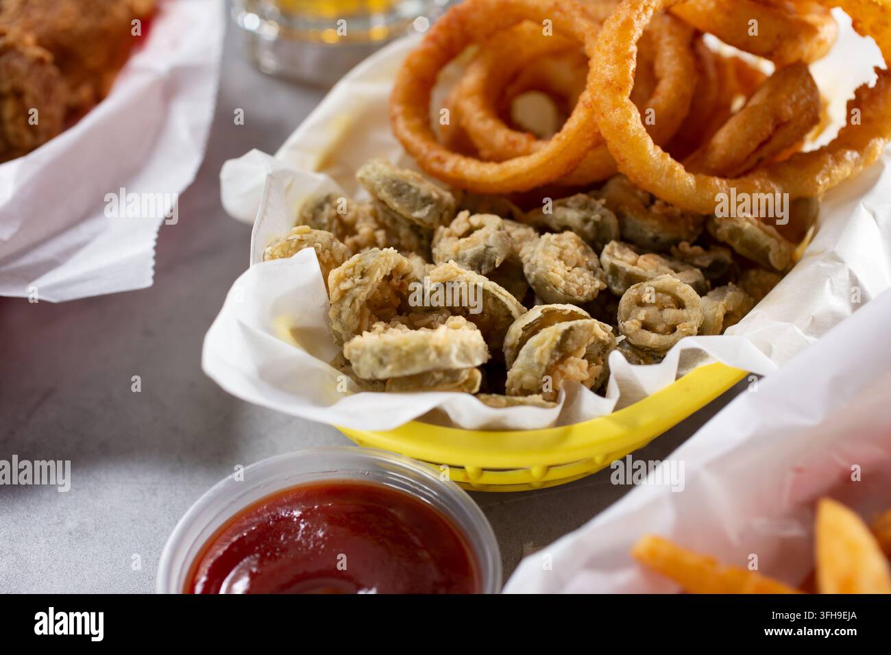 Eine Ansicht eines Vorspeisenkorbs mit tiefgebratenen Jalapeño-Scheiben und Zwiebelringen. Stockfoto