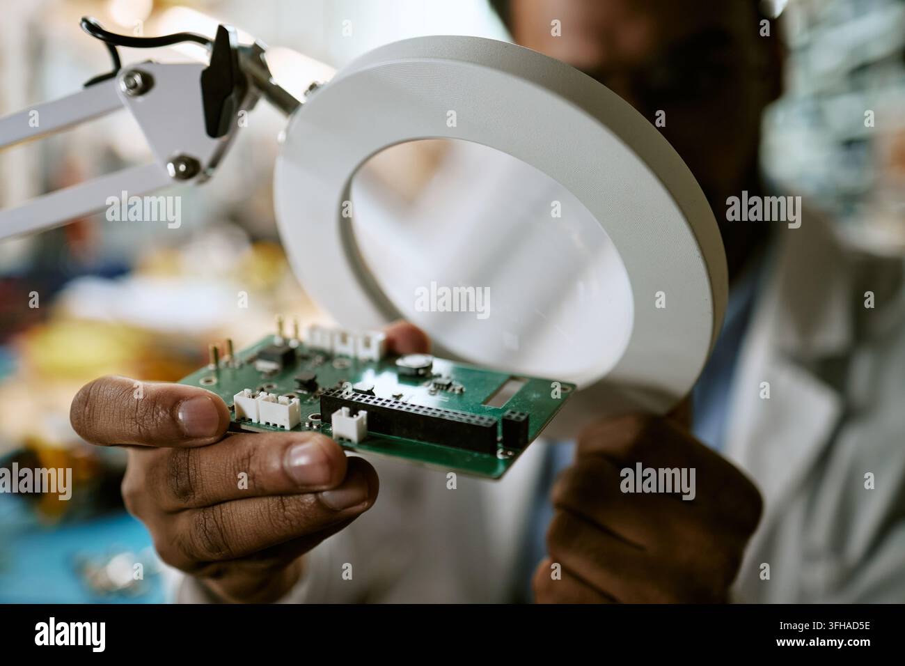 Ingenieur untersucht Leiterplatte mit Lupe im Labor Stockfoto