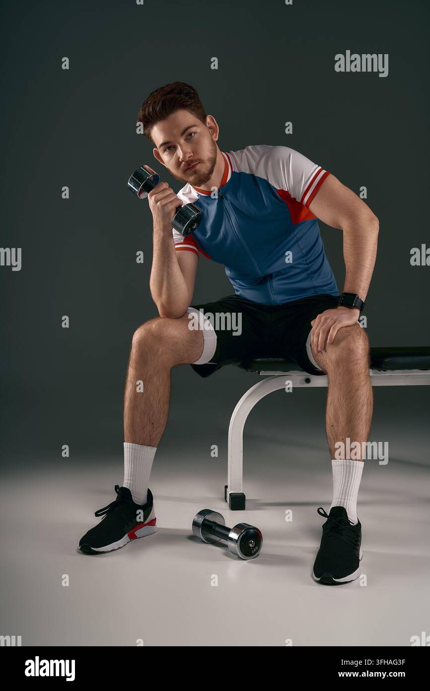 Attraktiver Athlet macht eine Pause nach einem harten Training und strahlt Selbstvertrauen und Konzentration aus. Stockfoto