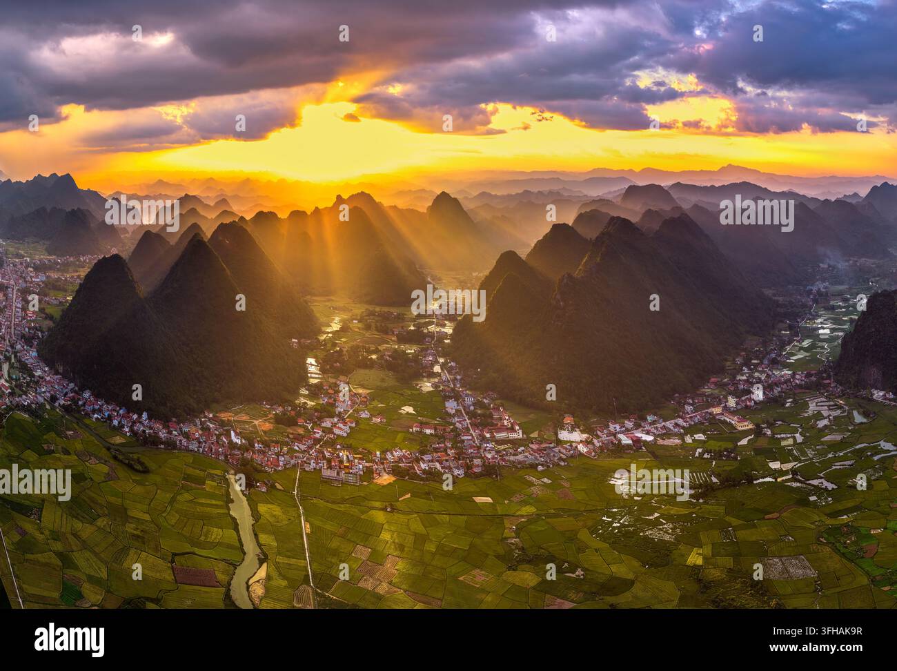 Dramatischer goldener Sonnenuntergang über das Bac-Son-Tal mit Kalkstein-Karstbergen und grünen Reisfeldern in der Provinz Lang Son, Nordvietnam. Stockfoto