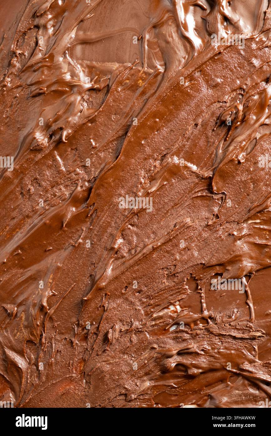 Cremige Milchschokoladenpaste mit strukturierten Spachtelstrichspuren. Stockfoto