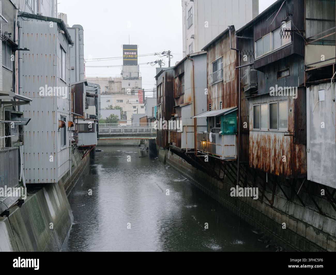 Japan heruntergekommene Wohnbebauung, Slum, städtischer Verfall mit Gebäuden, die über einem Kanal in Wakayama gebaut wurden Stockfoto