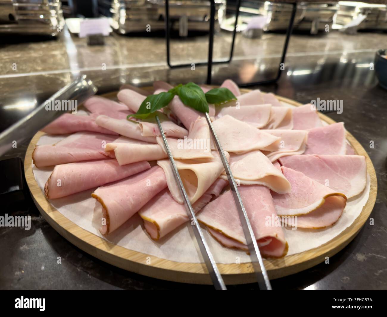Eine Nahaufnahme eines farbenfrohen Tellers, der eine vielfältige Auswahl an erstklassigen Delikatessen-Würsten präsentiert, perfekt für ein ansprechendes und luxuriöses Frühstücksbuffet oder Stockfoto