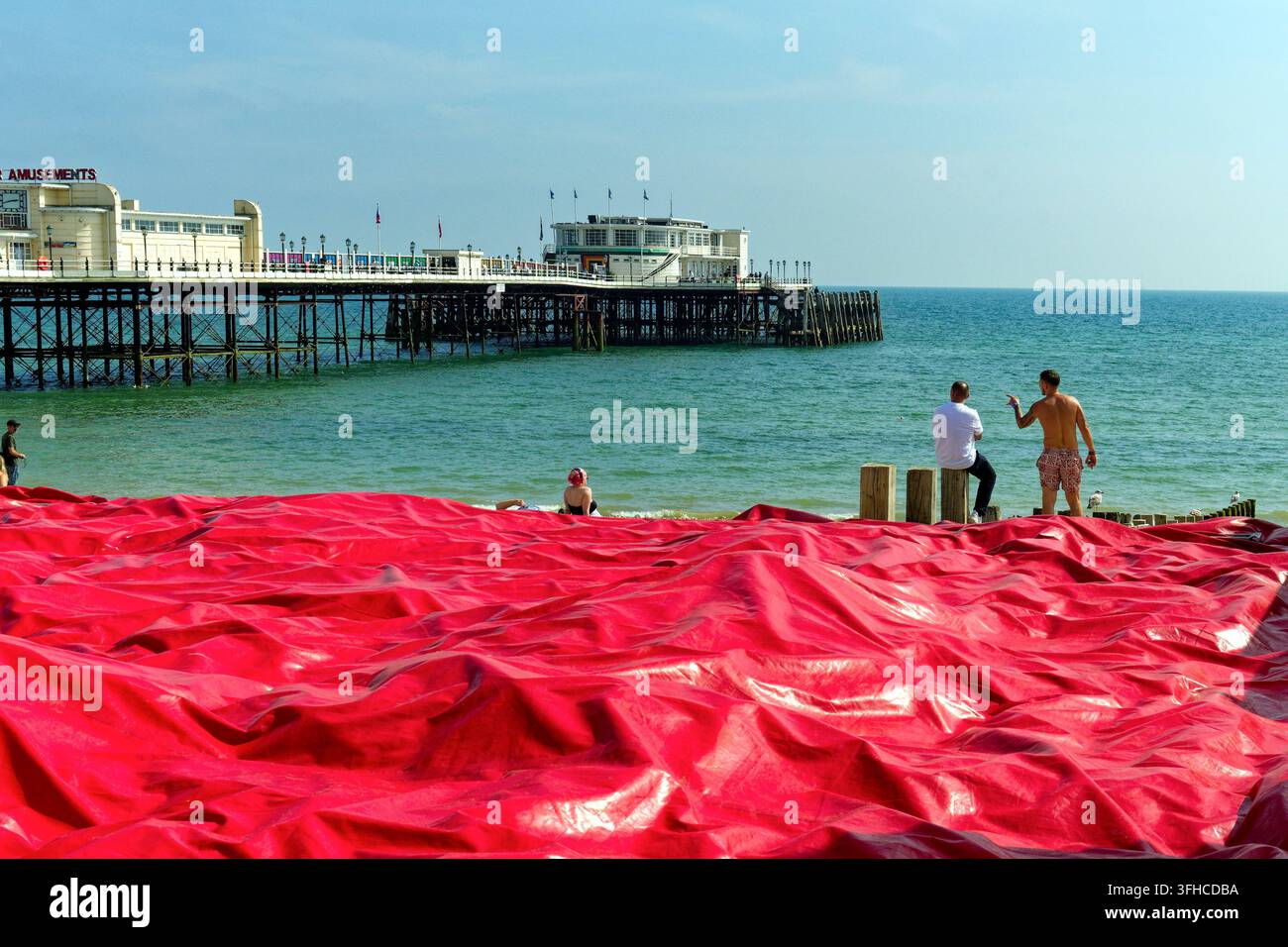 Worthing-Pier mit einem ungewöhnlichen roten Kunststoffmaterial, das den Strand bedeckt und einen abstrakten Effekt erzeugt Worthing West Sussex England UK Stockfoto