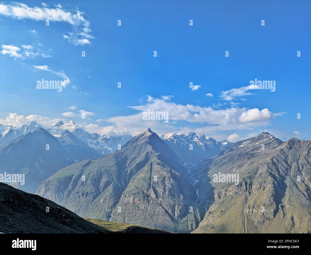 Atemberaubender Panoramablick auf schneebedeckte Berggipfel und dramatische Wolken am Rohtang-Pass, Manali, Himachal Pradesh, Indien - Smartphone-aufgenommenes Stockfoto