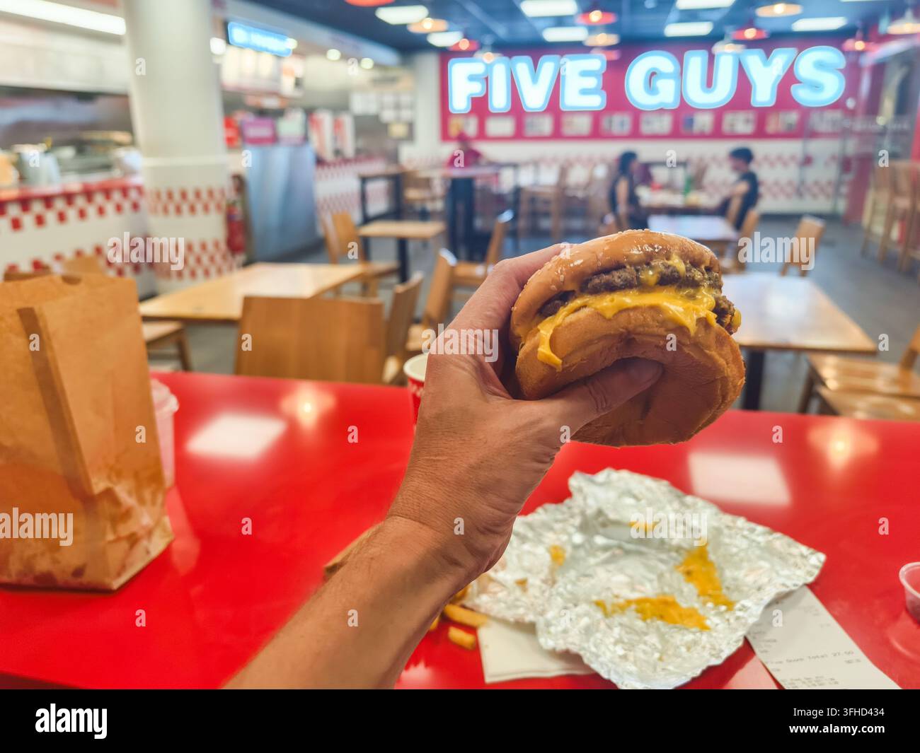 Hand hält einen klassischen Cheeseburger von Five Guys. Singapur Stockfoto
