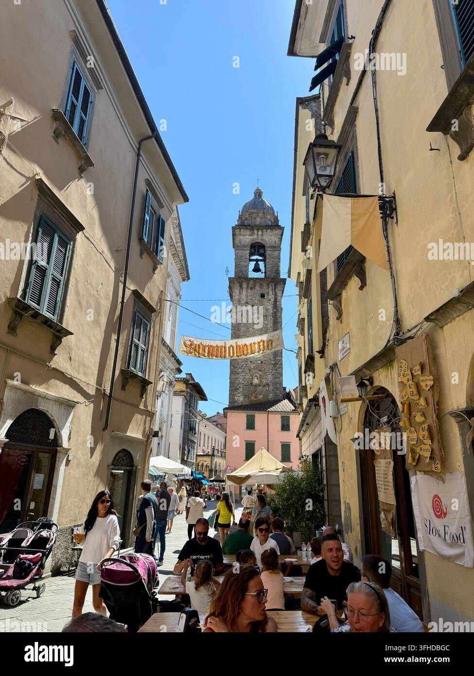 Medievalis-Mittelalterfest im historischen Zentrum von Pontremoli, Toskana, Italien, mit dem Campanone-Glockenturm, der über einer belebten Straße aufragt Stockfoto