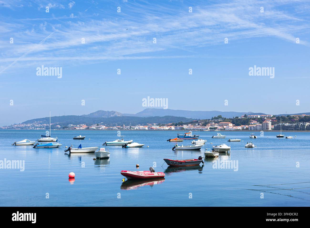 Scenische Ansicht mit kleinen Fischerbooten und Handwerksbooten, die in den ruhigen Gewässern der Mündung des Minho-Flusses in Caminha im Norden Portugals vor Anker liegen. Stockfoto