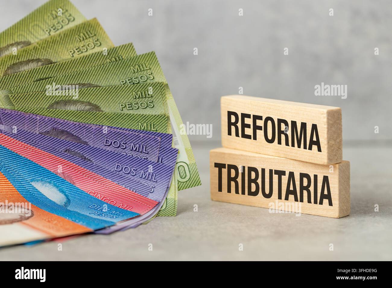 Konzept der chilenischen Steuerreform mit dem Text Reforma Tributaria auf Holzblöcken und chilenischen Peso-Banknoten. Finanz- und Geschäftskonzept Stockfoto