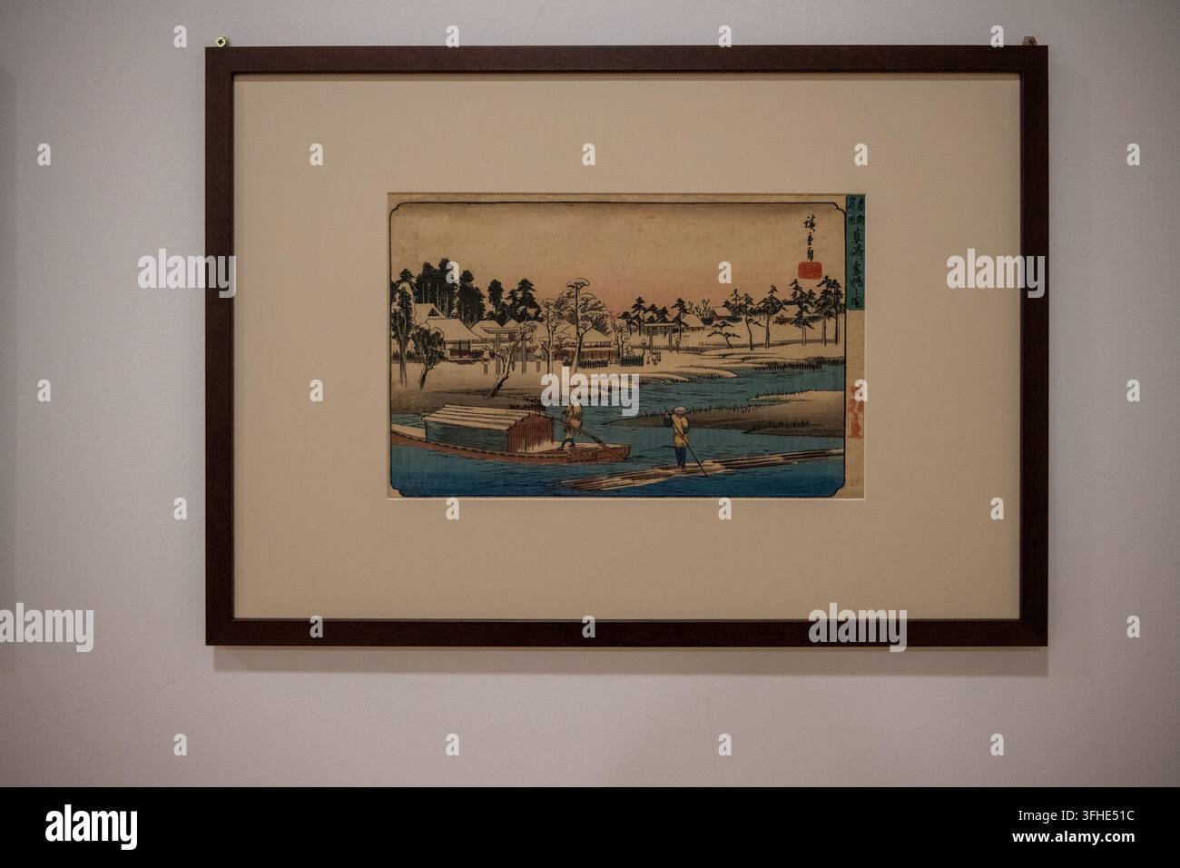 Bukarest, Rumänien - 6. Nov 25: Gerahmter japanischer Holzschnitt-Landschaftsdruck mit Flussbooten und entfernten Gebäuden im Nationalmuseum für Kunst in Bukarest Stockfoto