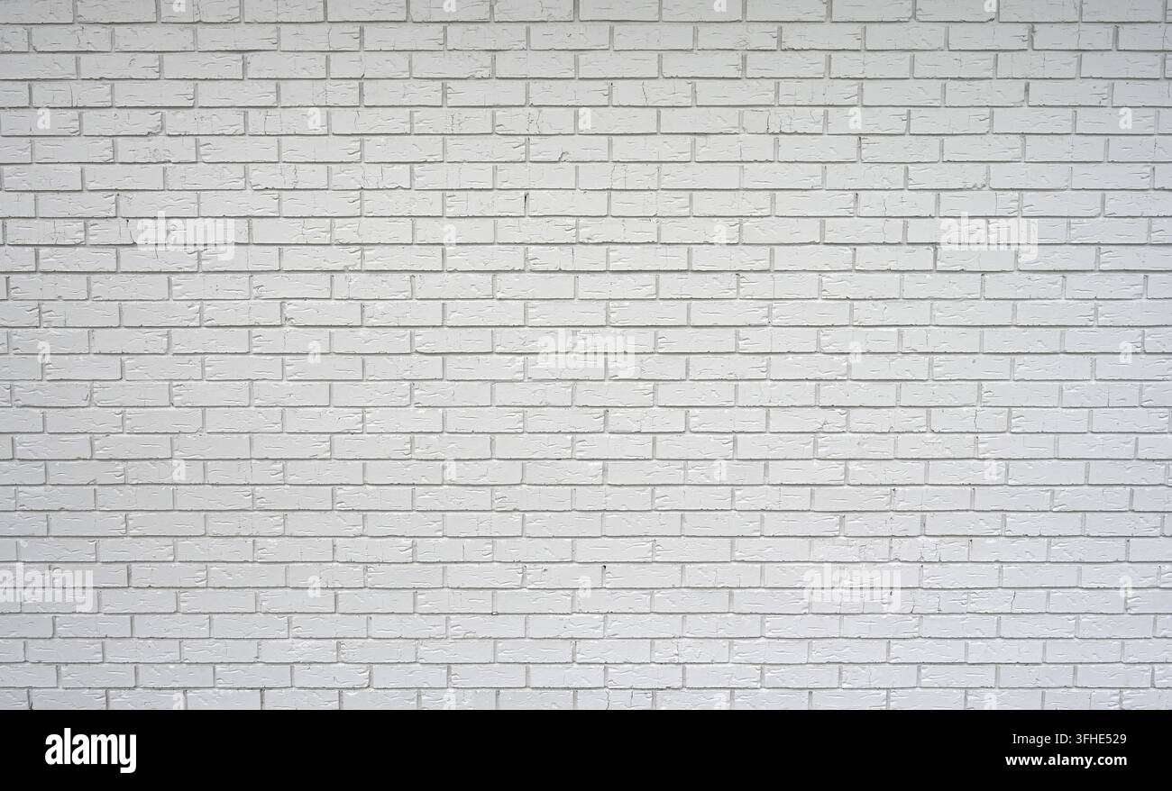Weiß gestrichener Lehmziegel und Mörtelmauerwerk in einem Standard-Stufenmuster, mit vertieften rauen Fugen, glatten, gerillten Ziegeloberflächen Stockfoto