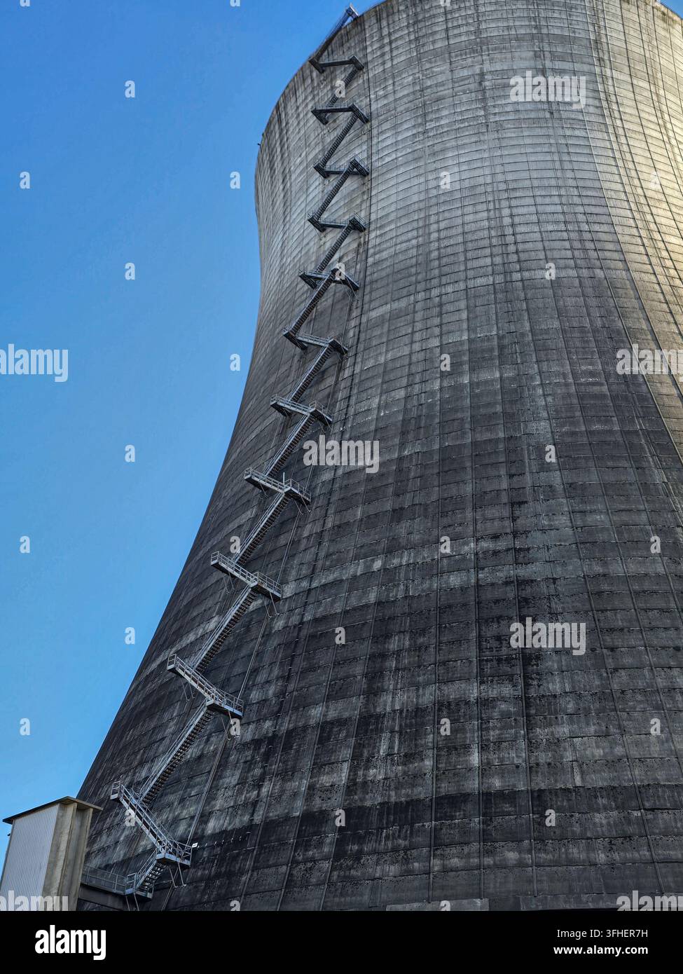 Niedrigwinkelaufnahme eines massiven Kühlturms im Kernkraftwerk Satsop im Bundesstaat Washington, der seine gebogene Betonhülle und das zickzackförmige m zeigt Stockfoto