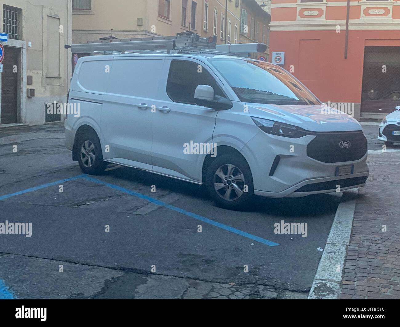 Cremona, Italien, 9. August 2026: Weißer Ford Transit Custom-Gewerbewagen mit Dachträger auf einer Stadtstraße, genutzt für professionelle Dienstleistungen und Fracht Stockfoto