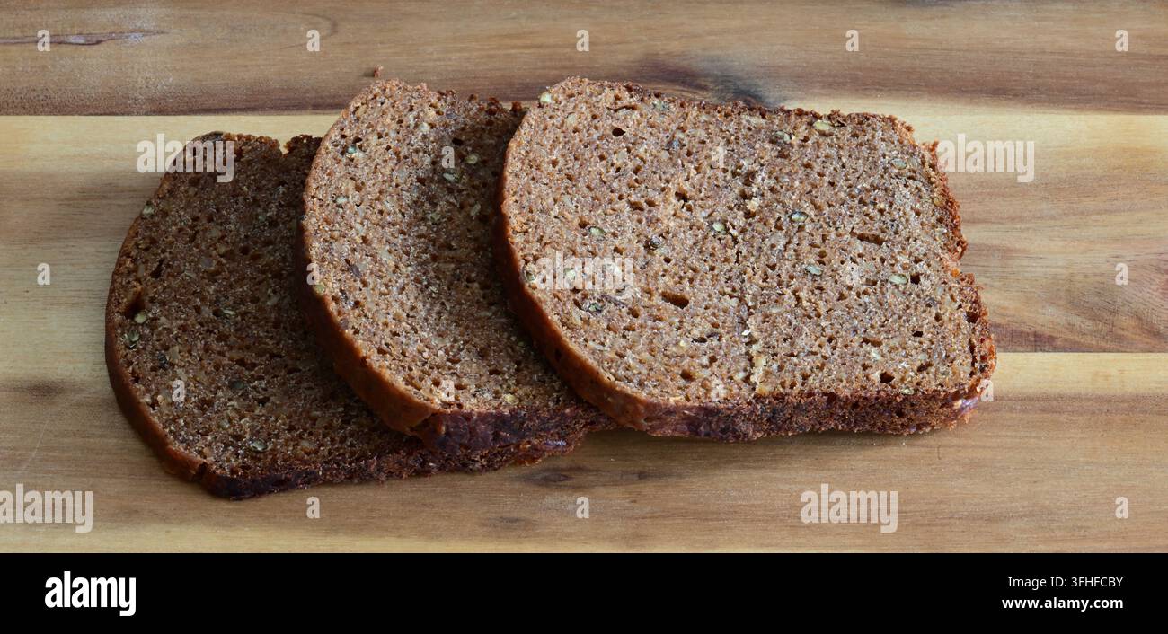 drei Scheiben Borodinsky-Brot auf dem Holzbrett Stockfoto