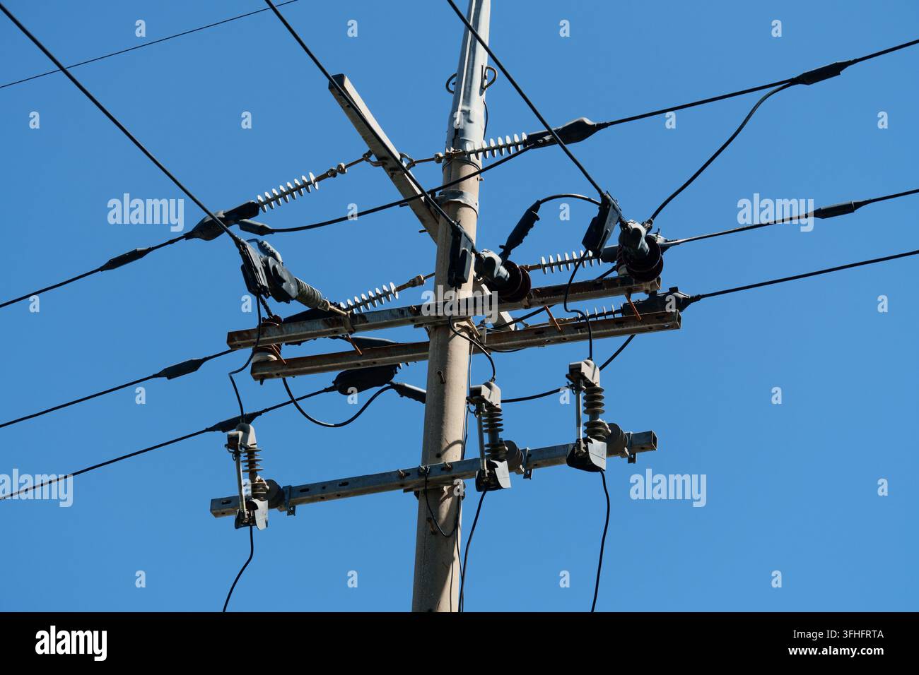 Strommast und Freileitungen unter blauem Himmel Stockfoto