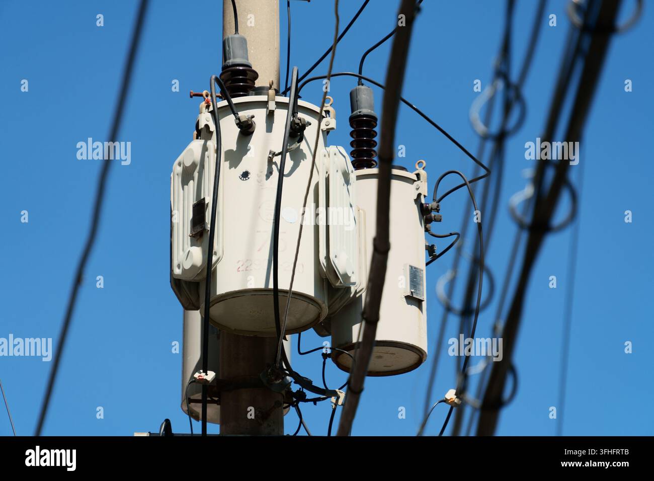 Auf Pfählen montierte Transformatoren im städtischen Stromverteilungsnetz Stockfoto