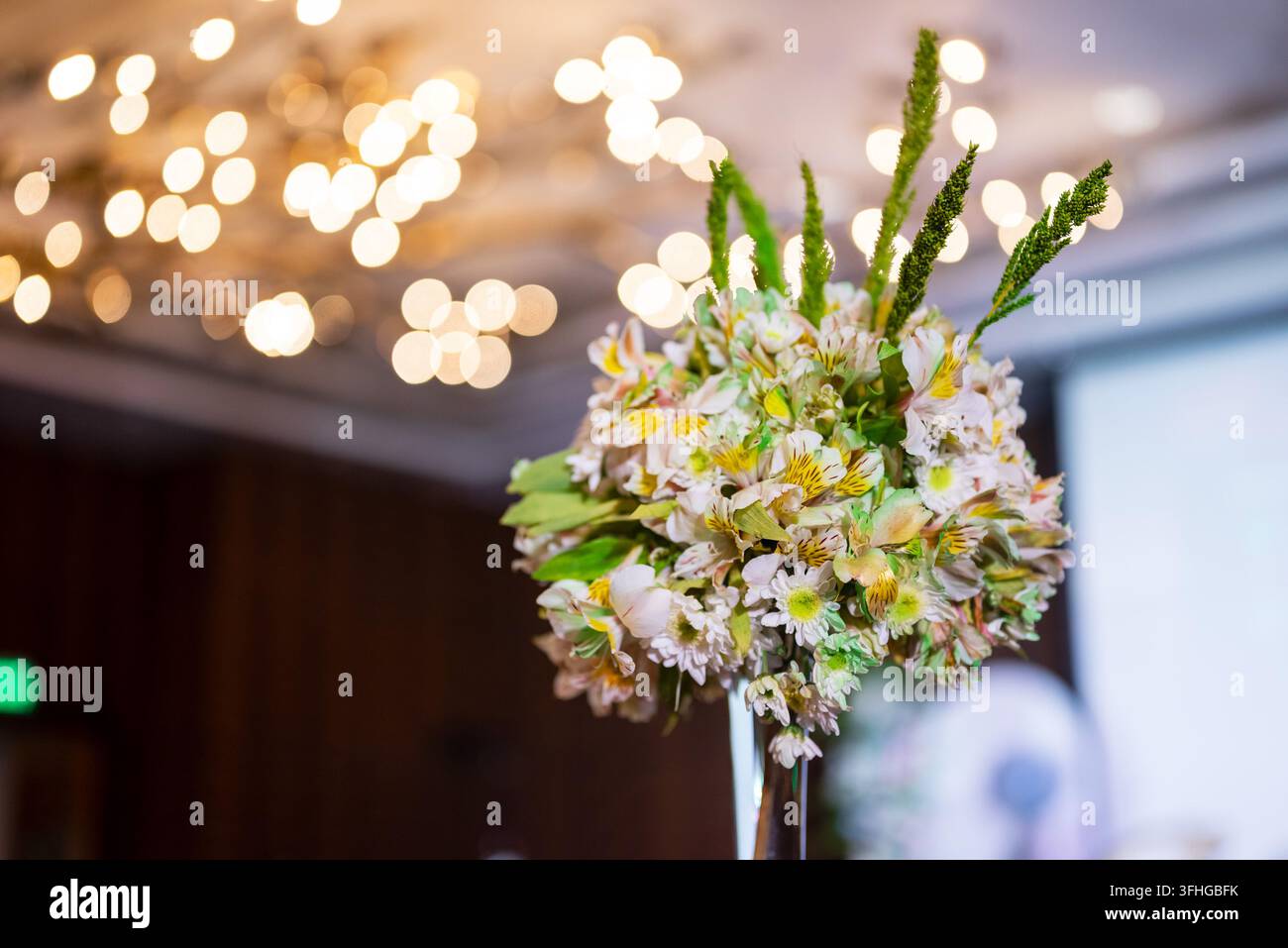 Elegante Blumengesteck mit warmen Bokeh-Hintergrundlichtern Stockfoto