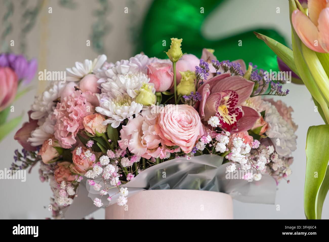 Weiche rosa Rosen, lebendige Orchideen und zarte Schleierblumen kombinieren sich in einer stilvollen Schachtel zu einer raffinierten Blumenkomposition, perfekt für Roman Stockfoto