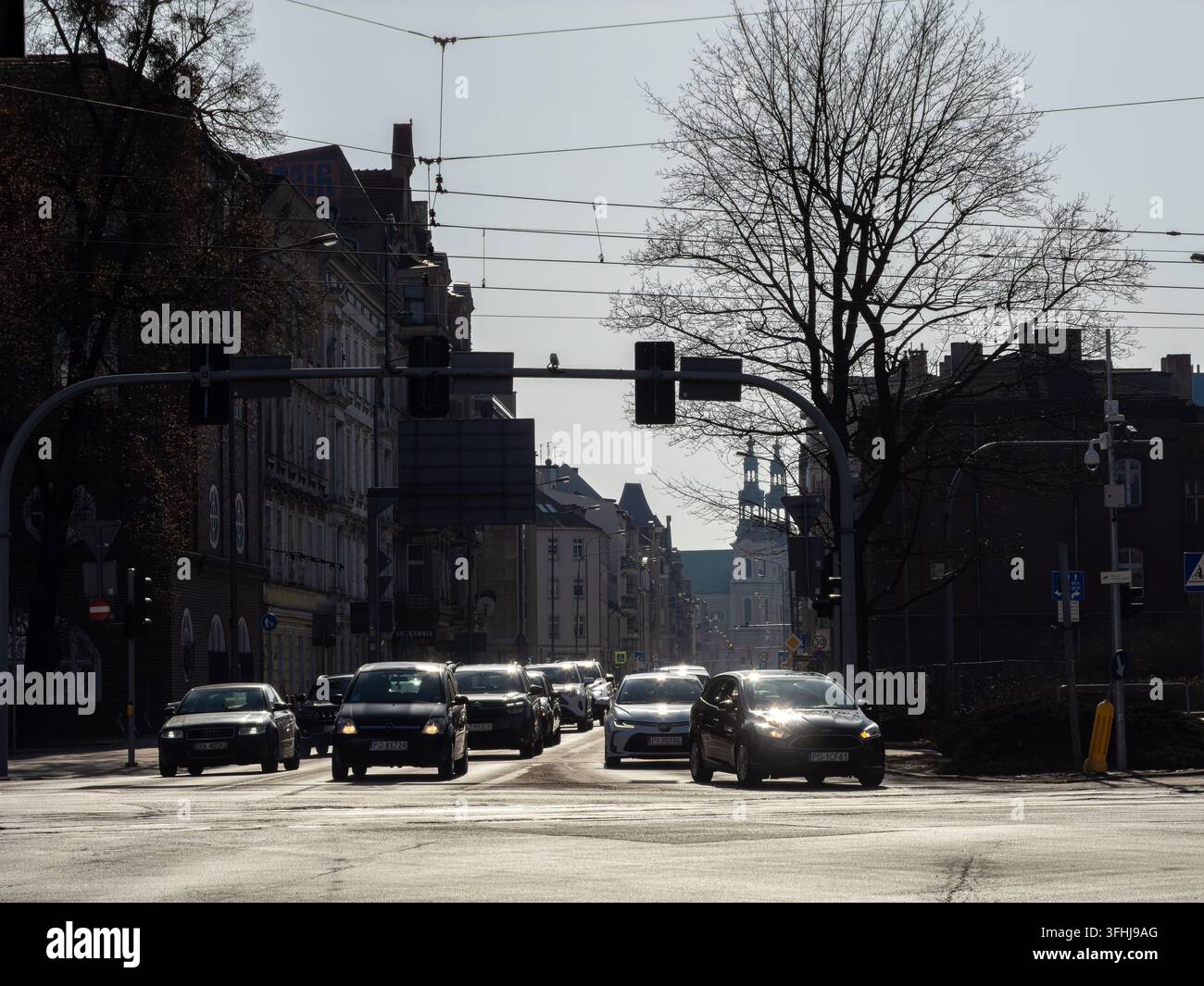 Posen, Polen – 28. Februar 2026: Der städtische Verkehr fließt an einem klaren Nachmittag durch eine Innenstadt-Kreuzung, während Fahrzeuge an historischer Architektur vorbeifahren Stockfoto